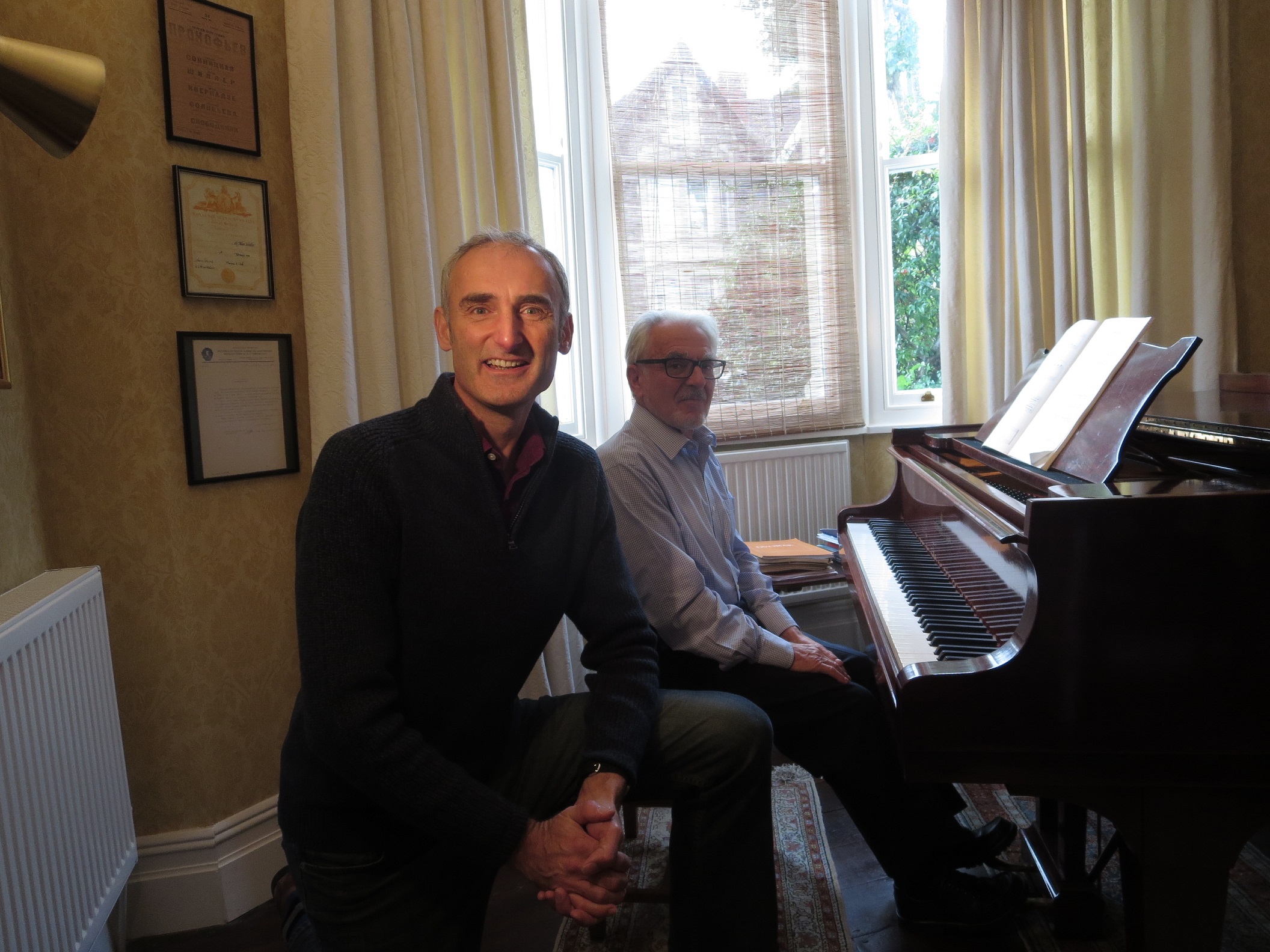 Kevin Lindegaard introduces pianist Allan Schiller who is sat at his piano playing Simple Gifts
