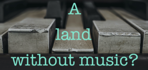 Battered piano keys in black and grey with the text A Land without music?